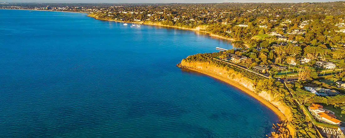 Bird's eye view of Mornington Peninsula coastline at sunset. Melbourne, Victoria, Australia for Exploring the relationship between healthy bays and healthy economies in Victoria