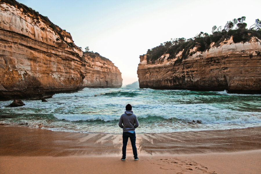 A man standing on the beach at Port Campbell for Measuring environmental, social and economic outcomes for the Great Ocean Road