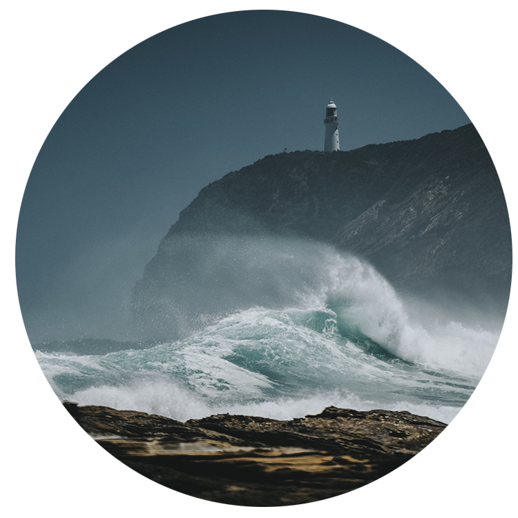 A lighthouse on a cliff with waves crashing