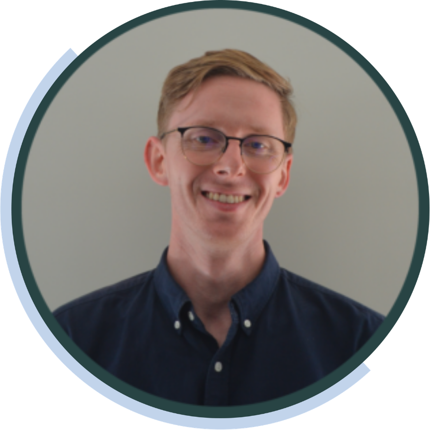 Daniel Whitaker, ideea group team member, smiling in glasses and a navy shirt